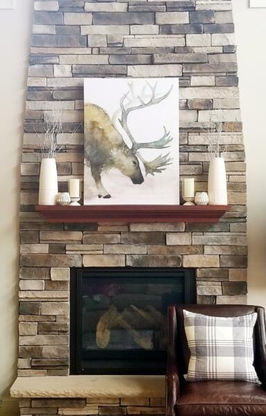 This fireplace vignette was created with the client's likes in mind and to addresss the very tall stone fireplace surround. So cozy!